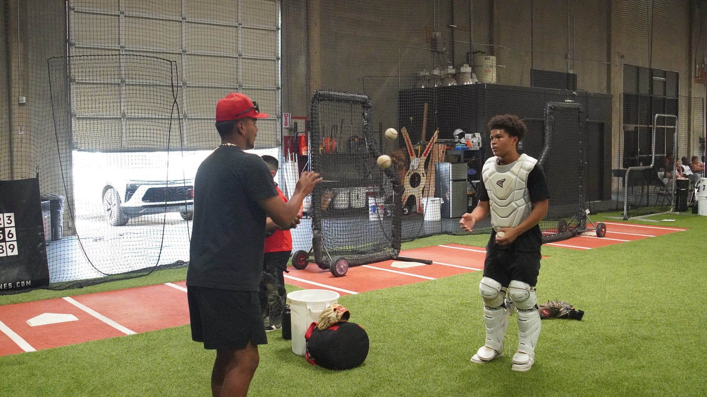 An Admirals coach works one-on-one with a catcher in full gear at the Sacramento facility