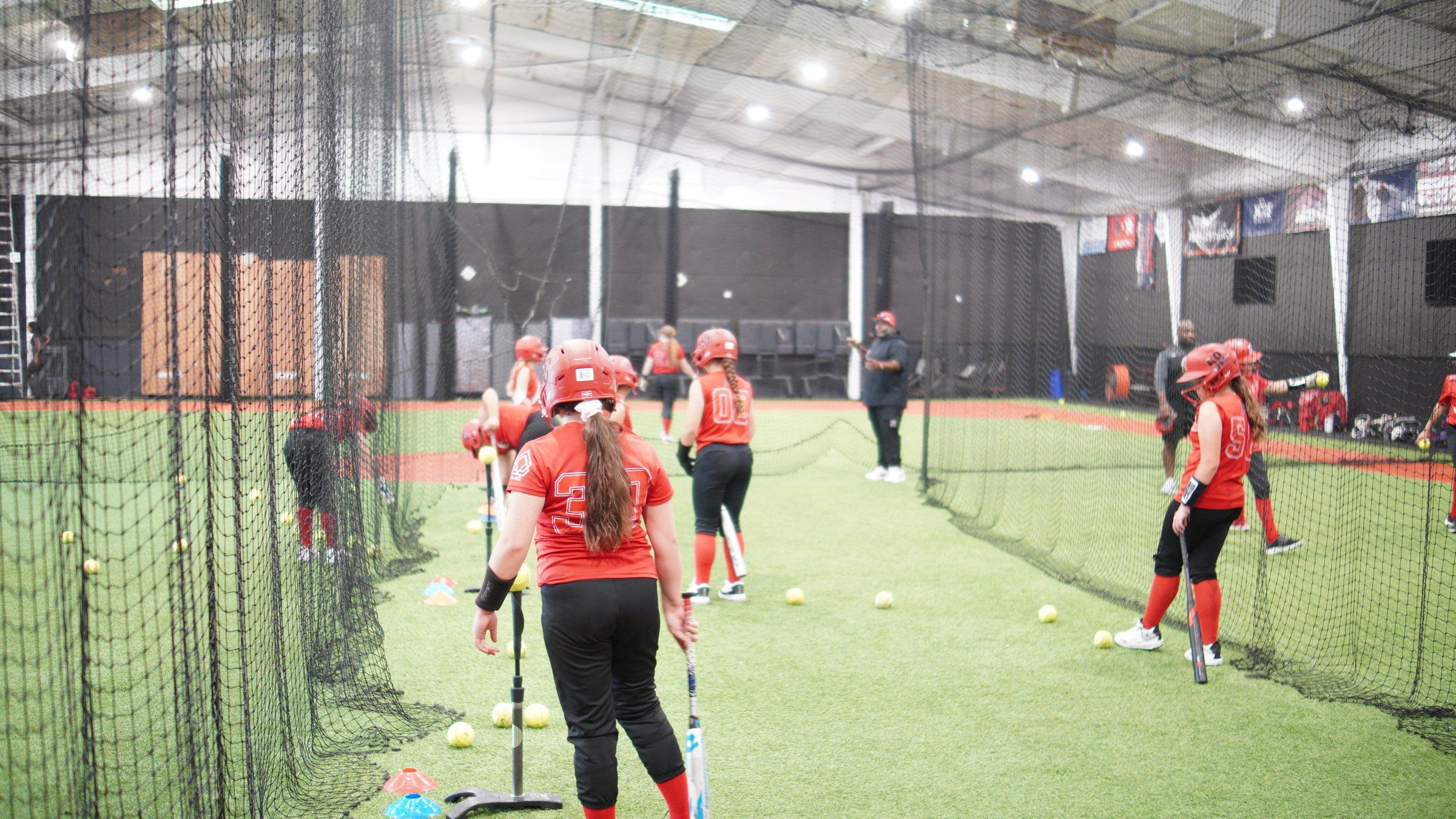 A group of Lady Admirals softball players hit off tees along the cage line at The ACE in Vacaville