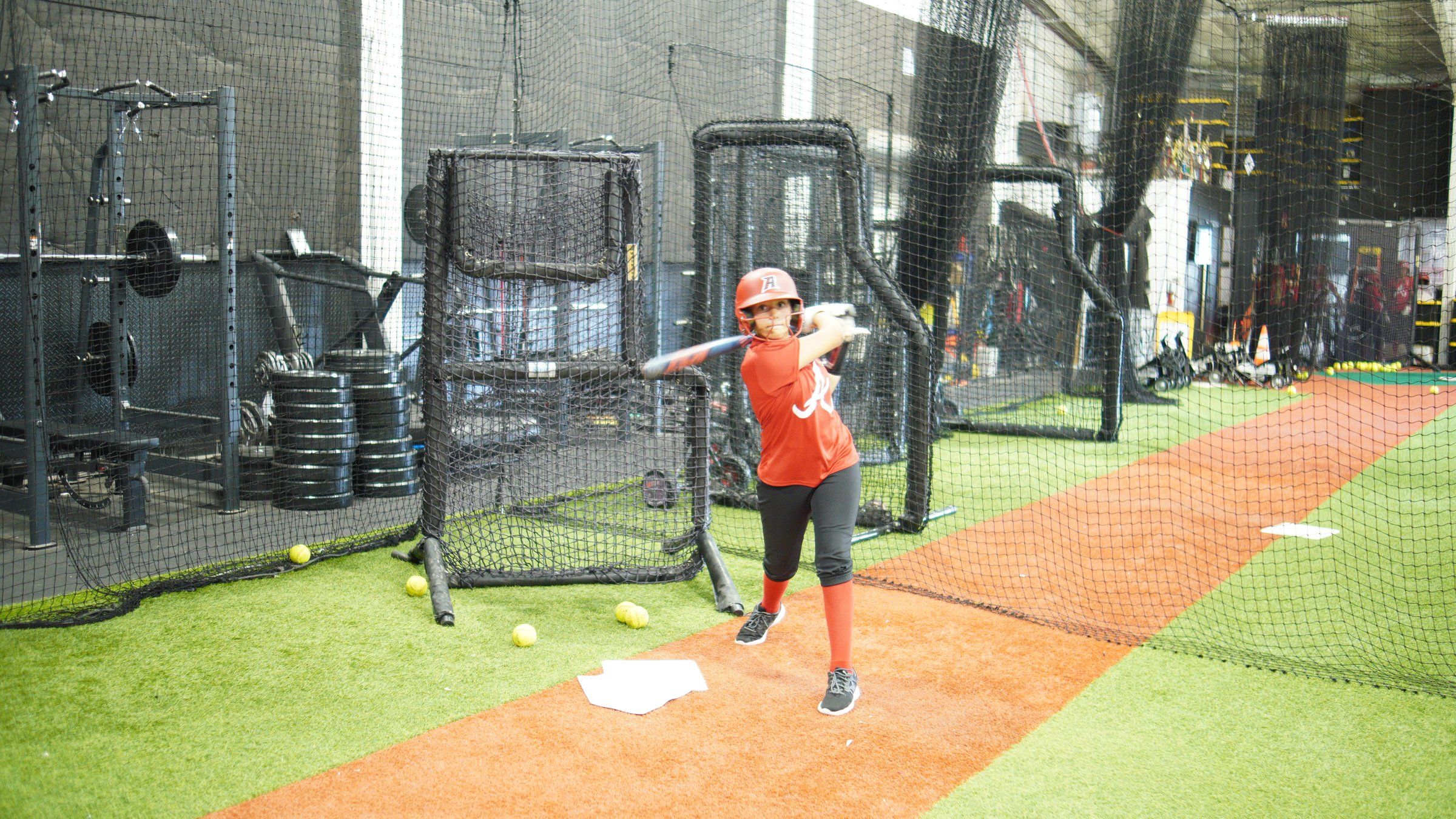 A Lady Admirals hitter drives a softball off front toss at The ACE in Vacaville